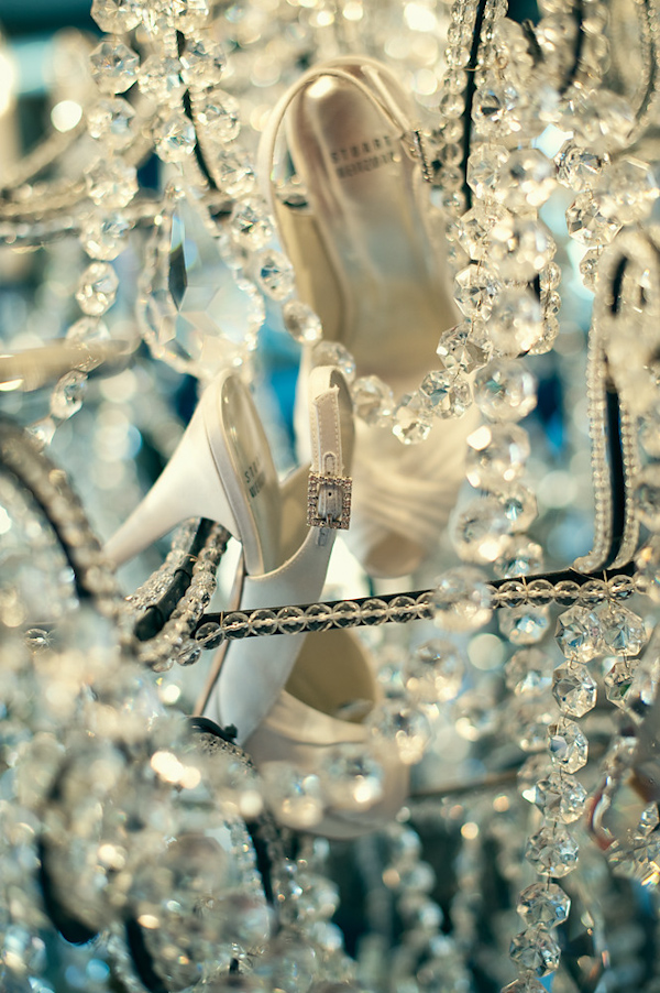 the bride's shoes dangling from the chandelier - photo by Houston based wedding photographer Adam Nyholt